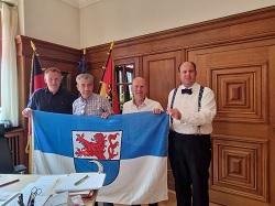 Andre Hüsgen, Tim Lochner, Thorsten Pohl und Nico Ernst mit einer Remscheid-Fahne im Pirnaer Oberbürgermeister-Büro